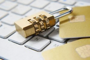 A padlock and credit cards resting on a keyboard, representing cybersecurity