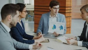Team of project managers discussing charts in a meeting
