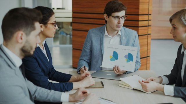 Team of project managers discussing charts in a meeting