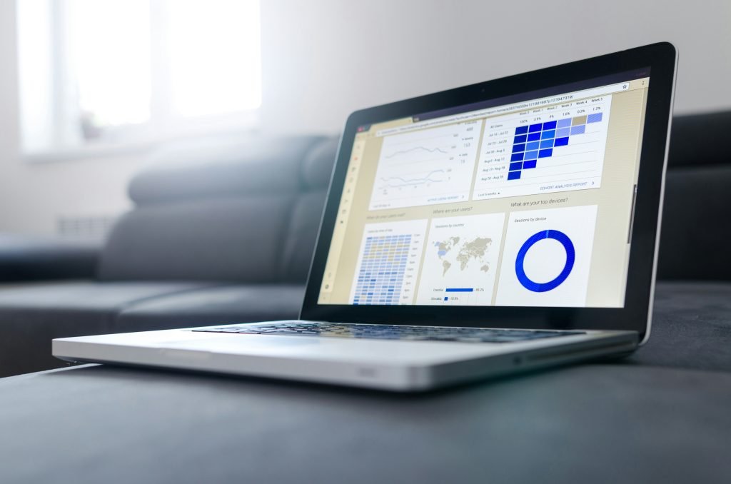 Laptop screen showing a project tracking analytics dashboard with charts and graphs