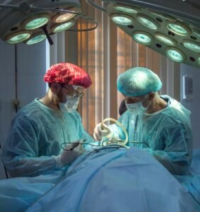 Surgical team operating under theater lights in an operating room