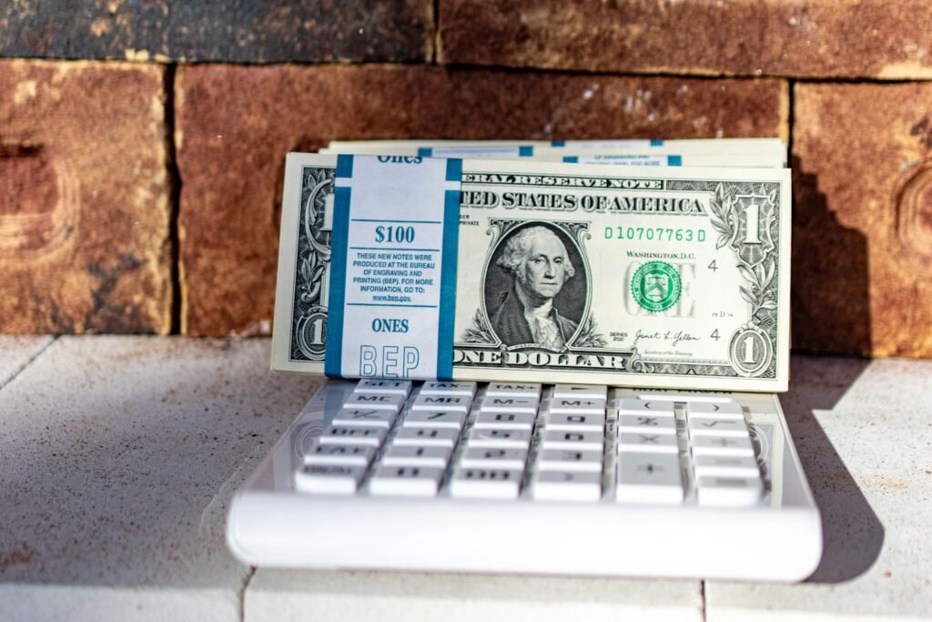 A stack of banknotes resting on a white calculator